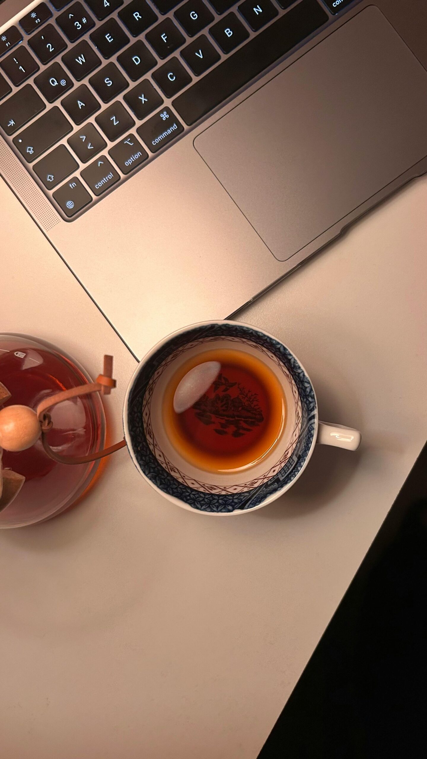 Warm desk setup with tea cup and laptop. Ideal for work inspiration.